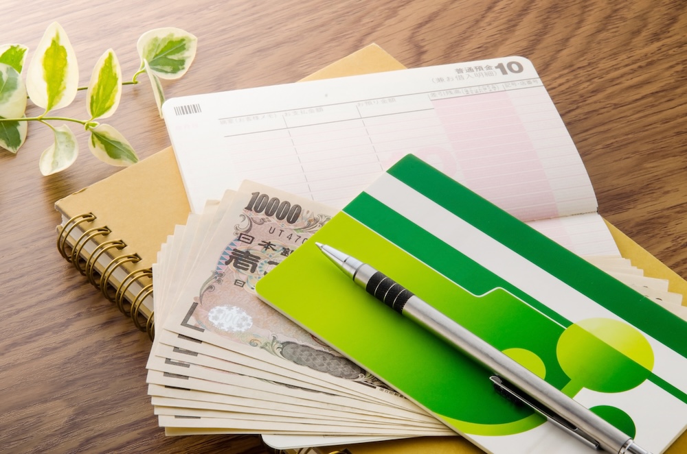 机に置かれた通帳とお札とメモ帳